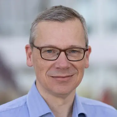 A close-up image of Arjan Berntsen in semi-formal clothing looking at the camera